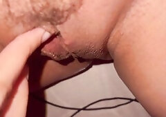 The cutie plays with her curly twat intensely, masturbating with her fingers and making squelching sounds.