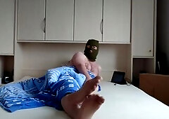 Füße in Strumpfhose und Maske im Bett