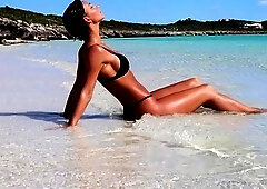 Beautiful brunette doing an erotic photoshoot at the beach