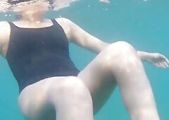 Blue water, ebony swimsuit, glamorous legs