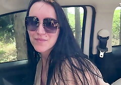 Long-haired woman gives deep throat blowjob in forest parking spot