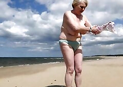 Wife walking undressed on beach