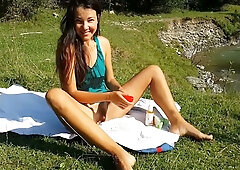 Woman takes a red vibrator and a man's cock in her ass outdoors by the river