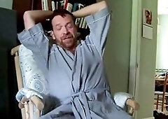 Hairy artist bathrobe highlights by a fan