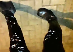 a crossdresser in high ram platform footwear and spandex stretch pants is ambling the streets at night