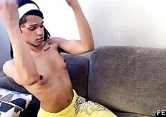 A light-skinned trans model with lengthy ebony hair and a large butt explores anal fun using a sextoy and pink sex toy whilst posing on a gray daybed 