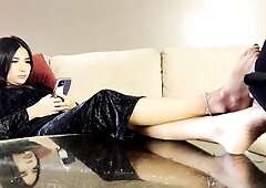 Sultry young mistress pleased by a masked foot fetish slave